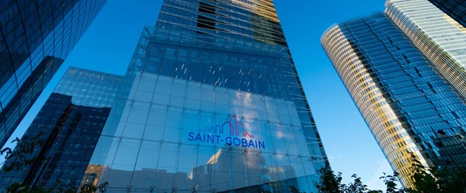 foto de um edifício da saint gobain, cercado de predios igualmente espelhados